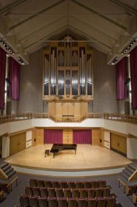 Pipe organ surrounding stage with grand piano
