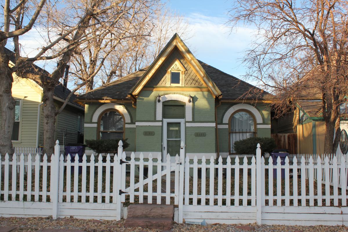 a house with a fence in front of a building