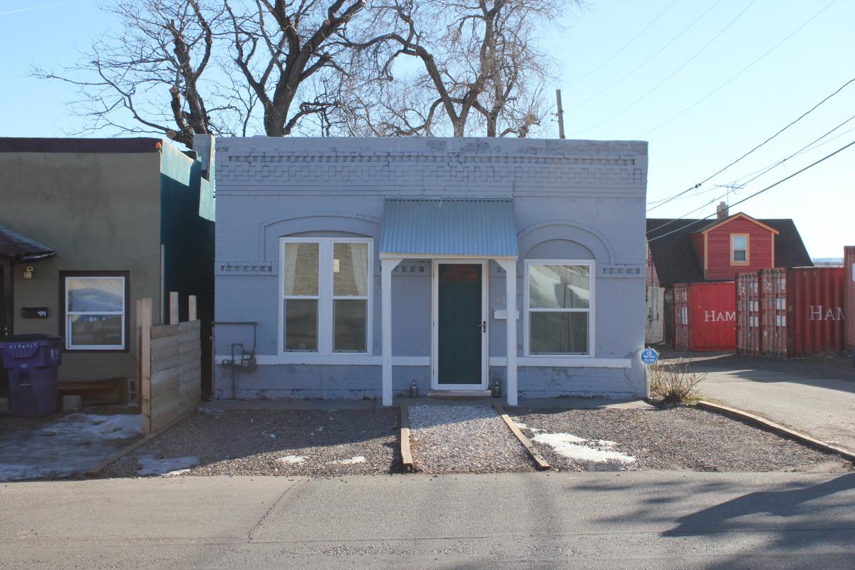 a house that has a sign on the side of a road