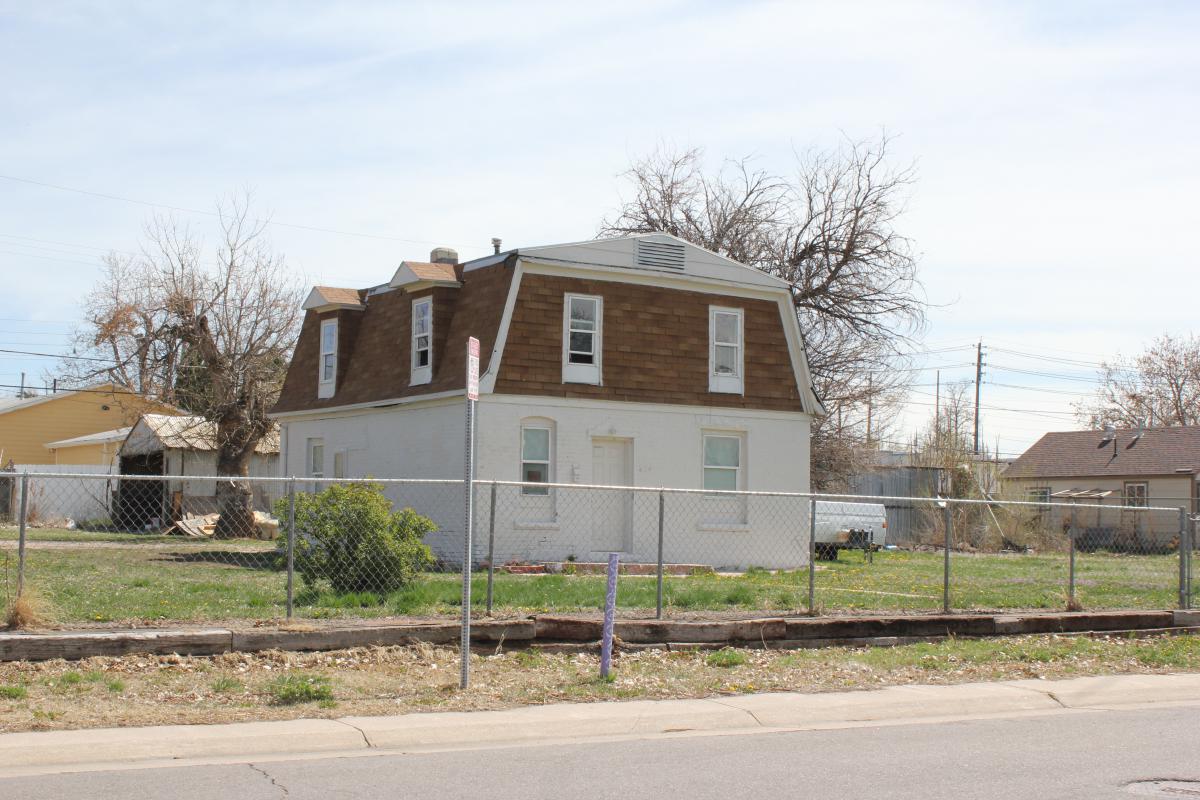 a house that has a sign on the side of a road