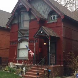 a large brick building with grass in front of a house