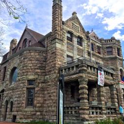 a large stone statue in front of a brick building