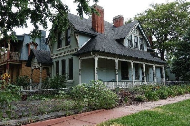 a large brick building with grass in front of a house