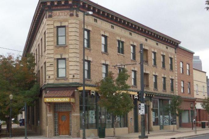 a large brick building with a store on the corner of a street