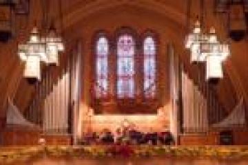 Church interior with large organ pipes and stained glass windows.
