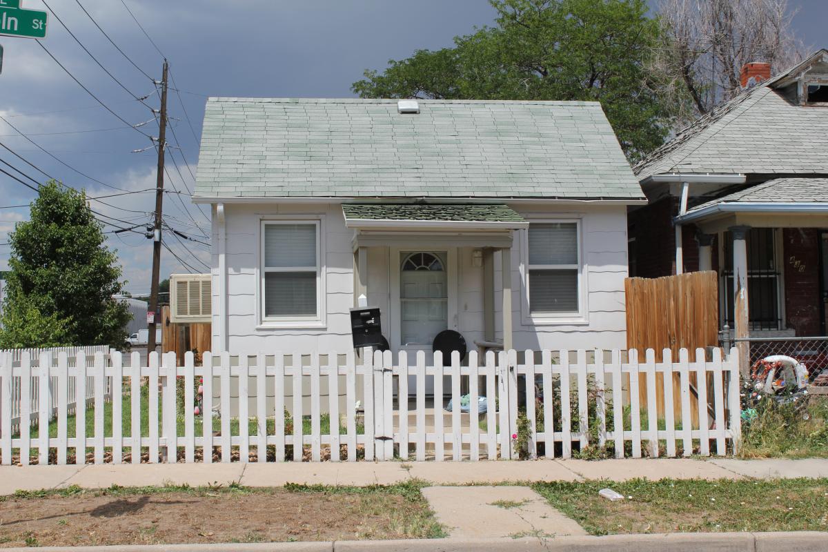 a house with a fence in front of a building