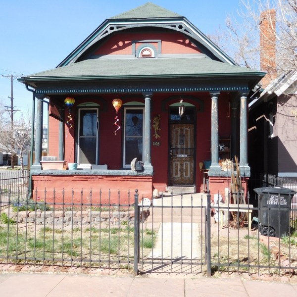 a house with a fence in front of a building