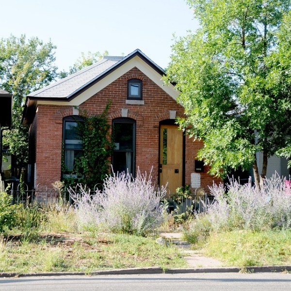 a house that has a sign on the side of a road
