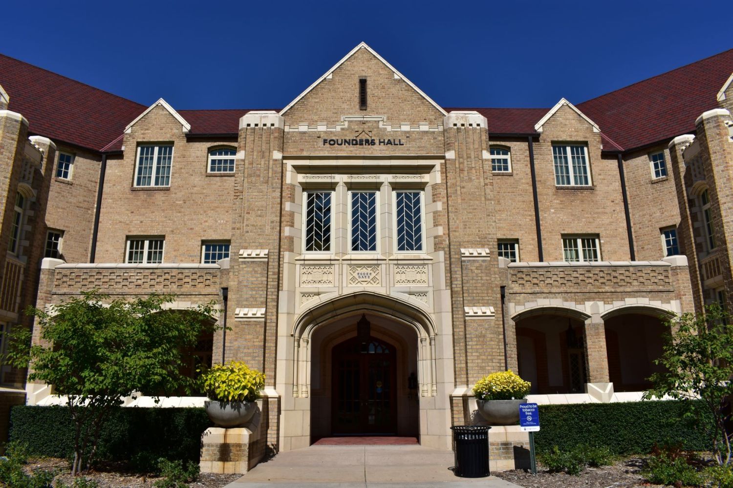 a large brick building with grass in front of a house