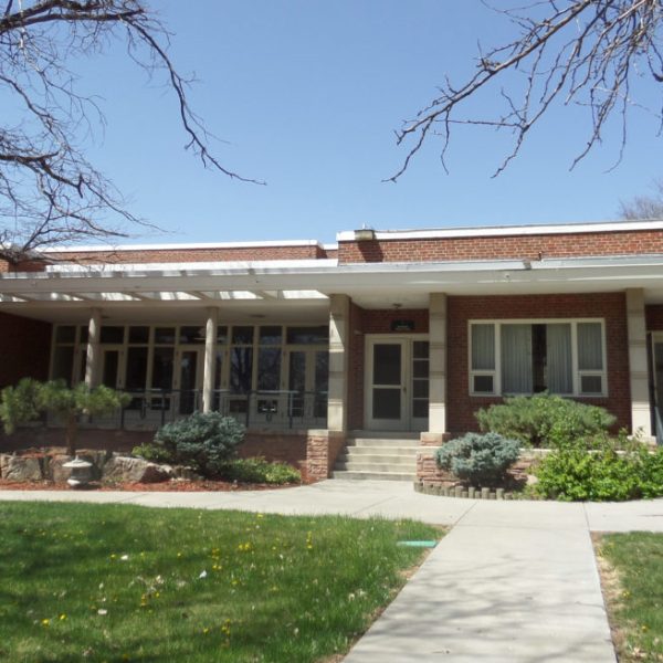 a large brick building with grass in front of a house
