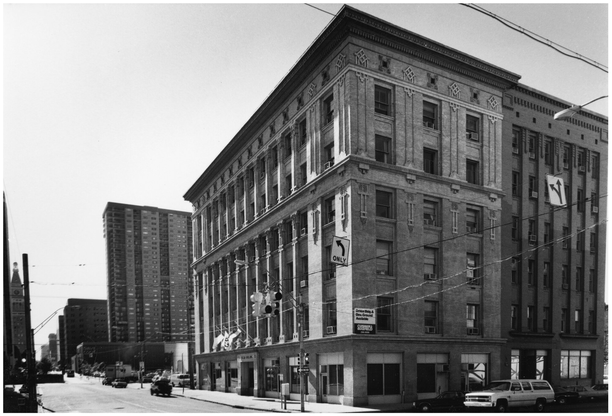 Black and white photo of a street corner with a historic multi-story building.