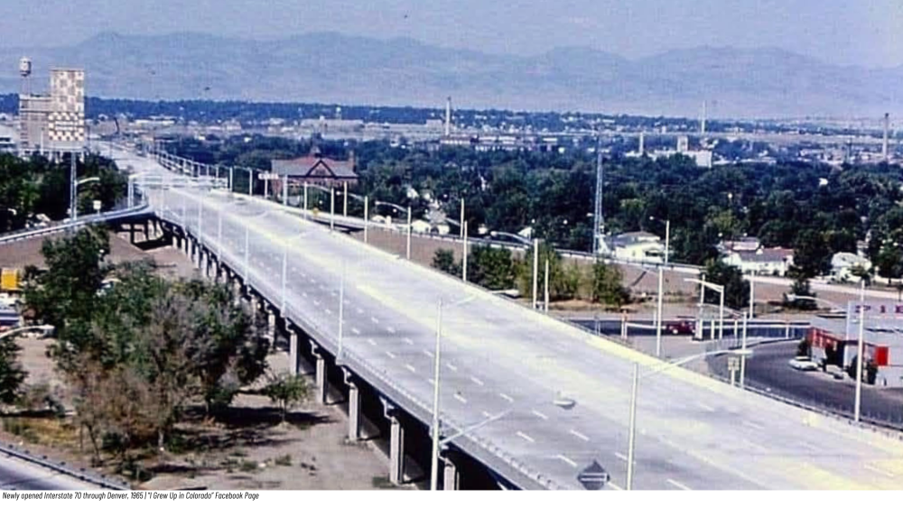 Elevated highway near urban area with mountains in the background.